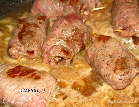 Через пару минут выкладываем в сковороду рулетики, подливаем немного кипятка, тушим рулетики минут 7, до готовности.