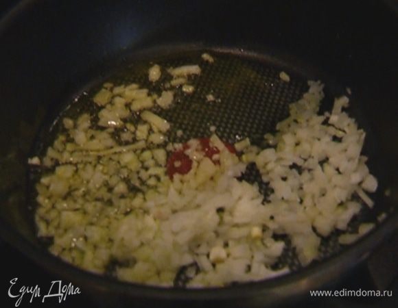 Разогреть в глубокой сковороде оливковое масло и обжарить лук до прозрачности.