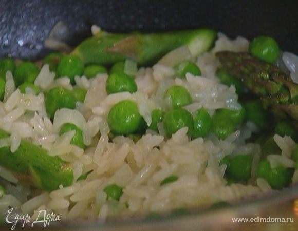 Добавить зеленый горошек, спаржу, посолить, поперчить, перемешать, влить еще 1–2 половника бульона, накрыть крышкой и довести до готовности.