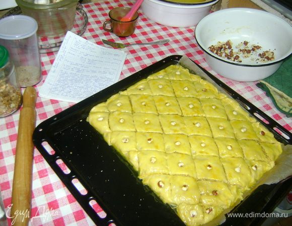 так вернемся к тесту:
из теста сформироовать шарики-колобки(разделив его на части у меня вышло 7 колобков....да уж не то что у мамы 12 слоев((((.....так из этих колобков 2 должны быть покрупнее чем остальные,чтобы потом лепешка-слой была толще ,чем остальные
На сухой противень(я застелила бумагой)раскатать тесто и выложить первый слой(толстый,ну относительно толстый)))...,смазать подготовленным маслом,насыпать начинку,разровнять рукой,,потом второй слой(тесто уже тонко расскатать)+масло+начинка,руками прижимать слегка слои,чтоб не оставалось меджу ними воздуха(пузыриков)...и тд...последний слой(толстый) ничем не смазывать,склеить края(я это делала по ходу,каждый слой склеивала...буквально на минутку поставить противень в разогретую духовку,достать,разрезать на ромбики,смазать поверхность смесью яйца с куркумой,воткнуть в серединку каждого ромбика орешек.