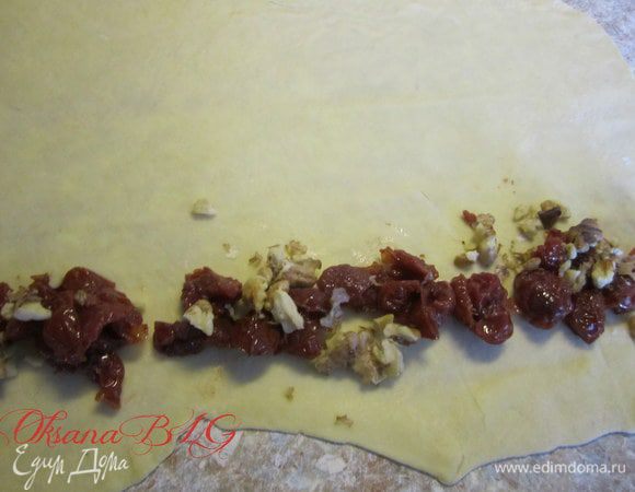 На край положите вишню, по желанию добавьте жареные грецкие орехи.