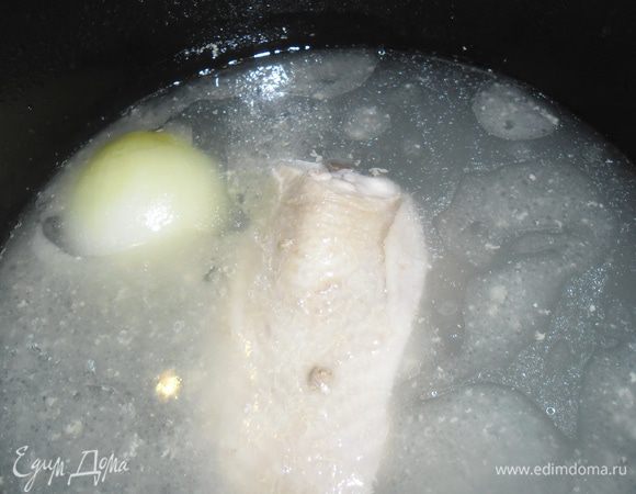 Куриную грудку залить 1.5 л. воды и варить на среднем огне снимая пенку. За 15 минут до готовности опустить в бульон очищенную луковицу, посолить. Снять бульон с огня, вынуть грудку и луковицу.