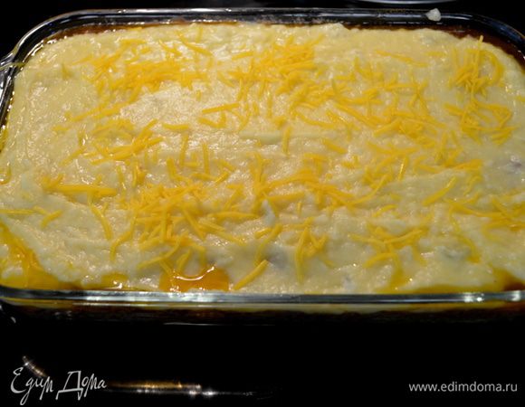 В прямоугольную форму выложить сначала слой фарша с овощами, затем картофель и сверху присыпать оставшимся сыром.