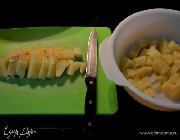 Положить картофель в кастрюлю и отварить.Дать постоять пока не будет достаточно холодным,чтобы его можно было взять в руки и порезать кубиками.