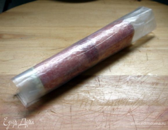 Закрутить, помогая себе пергаментом, в рулет. Нарезать рулет на кружочки в 1 см шириной.
