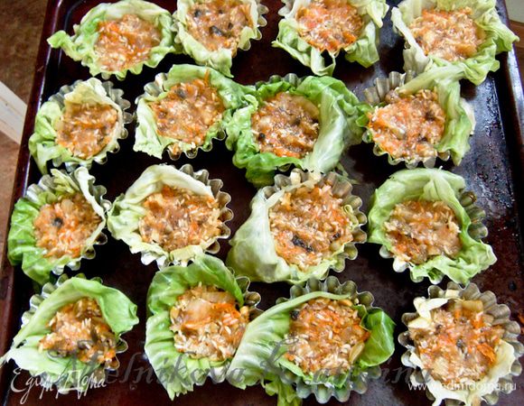 Формочки для маффинов смазать сливочным маслом. Капустные листики положить в формочки таким образом, чтобы оставался свисающий край. В каждую формочку выложить фарш.