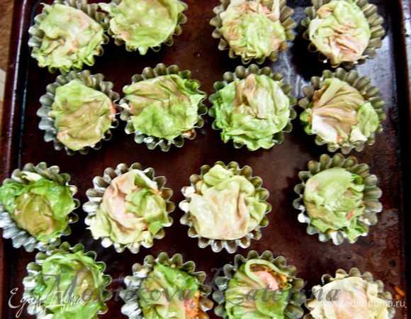 В каждую формочку положить по 1-2 ст.л. томатного соуса (в зависимости от величины формочки). Закрыть свисающей частью капустного листа, либо накрыть отдельным листиком сверху. 