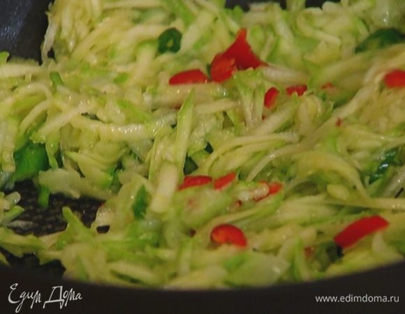 Разогреть в сковороде 1 ст. ложку оливкового масла и обжаривать кабачок, лук и перец чили на медленном огне 2–3 минуты.