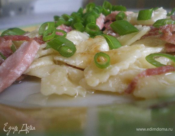 Макароны отварить по инструкции. Копчёности нарезать тонкой соломкой, обжарить. Добавить сметану и тушить. Затем добавить макароны, перемешать и томить 5-7 минут. Перед подачей украсить зеленью.