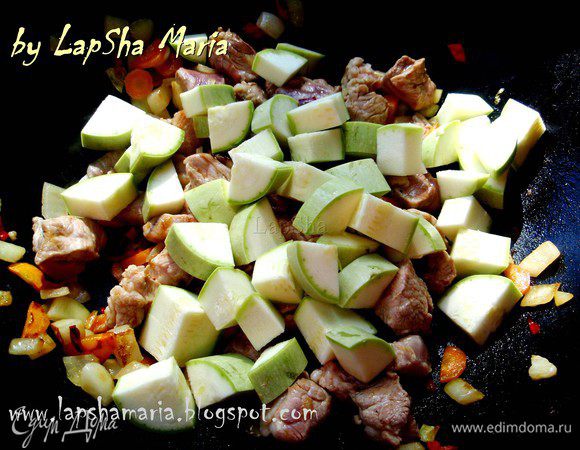 А пока у молодого кабачка отрежем попки и не очищая от кожуры нарежем на кубики такого же размера, как и мясо нарезали. Добавим к мясу с овощами и обжарим все вместе минут 5, помешивая.  