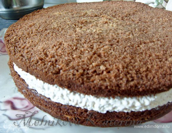 Сверху положить второй корж и на него выложить корж ореховой нуги (поскольку она будет застывшая, можно ее перевернуть пергаментом вверх прямо на корж и потом пергамент снять, он легко отделяется). На нугу положить еще один корж. 