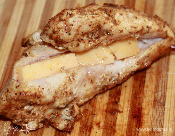 В обжаренные грудки разрезаем и ложим кусочки сыра.
