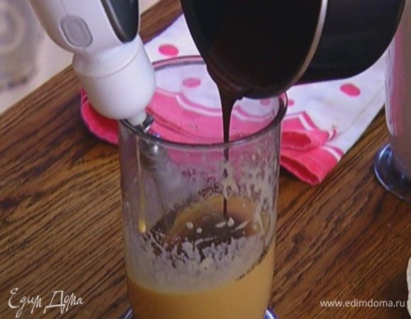 Растопленный шоколад слегка остудить, затем тонкой струйкой влить к желткам с сахаром, непрерывно вымешивая миксером. Добавить половину орехов, перемешать.