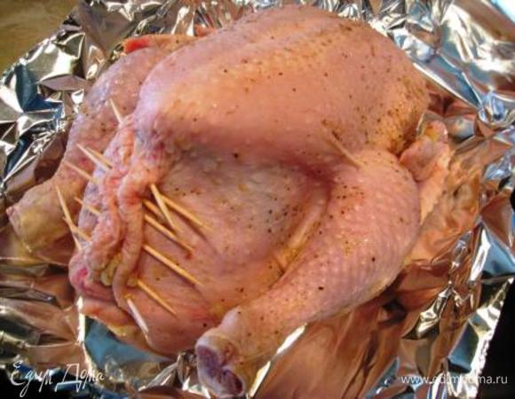 Фаршируем курицу сначала желтой частью риса, затем без куркумы. Закрепляем зубочистками. Заворачиваем в фольгу.