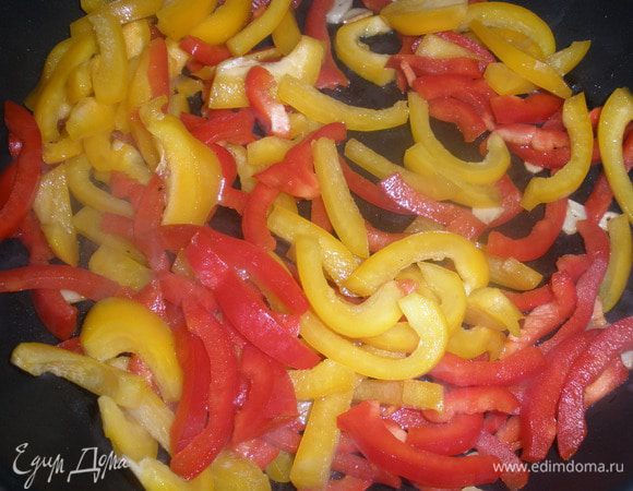 Разогреть в большой сковороде оливковое масло, слегка подрумянить чеснок на умеренном огне, чтобы не сгорел, добавить перцы. Все вместе обжаривать примерно 5 минут, постоянно помешивая. 