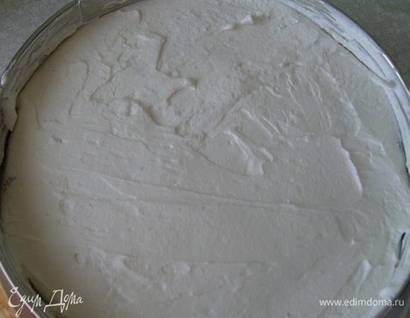 Накрыть вторым слоем бисквита, пропитать его сиропом, смазать 1/3 частью сливок.