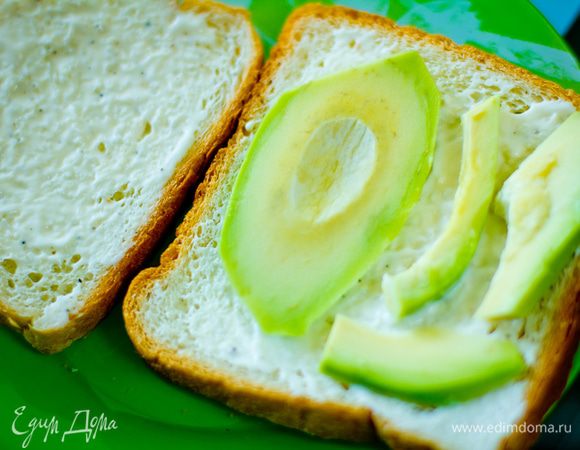 Тонко нарезанные ломтики авокадо выкладываем на хлеб