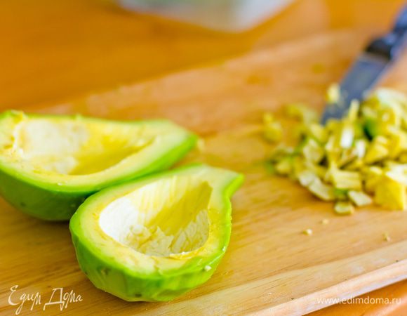 Срезаем с авокадо кожуру, аккуратно разрезаем авокадо на две части, вынув кость. Делаем углубление, срезам верхнюю часть мякоти. Вырезанную мякоть измельчаем