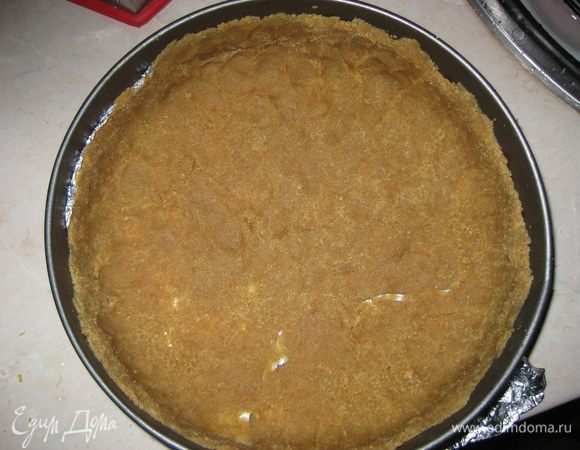 Форму для выпечки застилаем пергаментом, выкладываем массу из печенья, формируем бортики приблизительно на 2/3 высоты формы. Отправляем форму с основой на 30 минут в морозильную камеру.