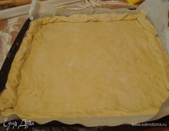 противень смазываем маслом(я еще для надежности выстилаю бумагой), аккуратно перекладываем тесто, делаем бортики

!чтобы переложить на противень такой большой пласт, нужно хорошо посыпать его мукой сверху, аккуратно сложить вдвое-вчетверо, переложить на противень и развернуть.