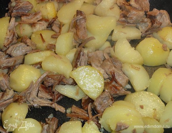 Возьмите сковороду в которой вы будете запекать блюдо. Обжарьте мясо и картофель на оливковом масле до золотистого цвета.