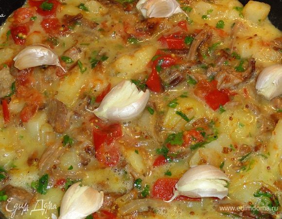 На поверхность разложите раздавленные зубчики чеснока. Поставьте в разогретую до 200 градусов духовку на 15 минут.