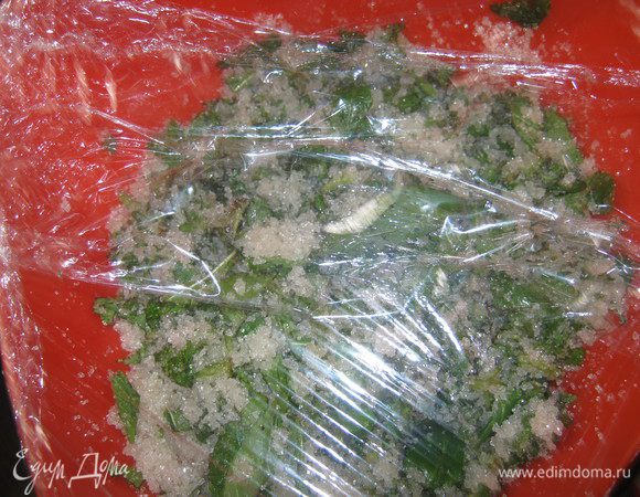 Затем мяту мелко режем,выкладываем в миску и засыпаем 250 г сахара. Миску накрываем пленкой и даем настоятся в течение 4 часов. 