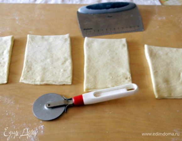 Достать тесто из холодильника и раскатать. Это нужно делать довольно быстро, потому, как только тесто согреется, оно начнёт расти у вас в руках. Колёсиком (или ножом) нарезать тесто на 10 прямоугольников, которые затем нужно нарезать на 20 треугольников.
