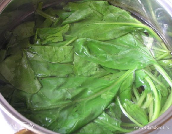 Шпинат промыть, опустить в кипящую воду на 1 минуту, затем откинуть на дуршлаг, чтобы стекла лишняя жидкость,