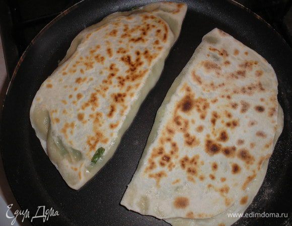 Обжариваем на сухой сковородке на среднем огне с каждой стороны, до появления светло-коричневого цвета. Смазываем горячие кутабы сливочным маслом.