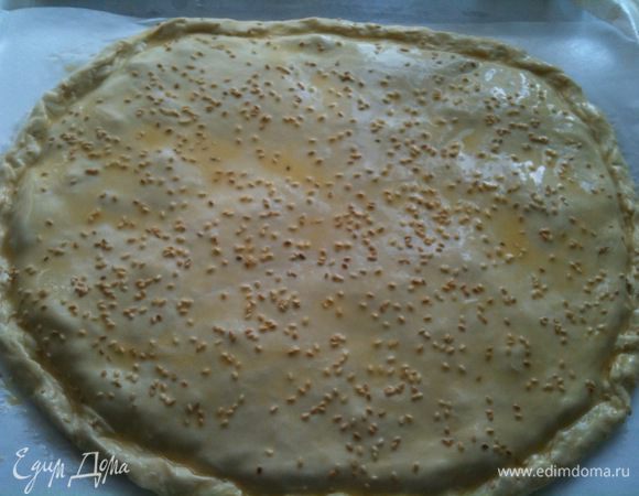 Раскатать вторую часть теста и накрыть начинку. Хорошо защипать по краям пирога. Спазать сверху взбитым яйцом и посыпать кунжутом. Сделать частые проколы зубочисткой, для выхода пара...