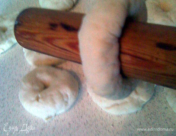 Теперь берем скалку,нанизываем на неё бублик и начинаем прокручивать его на скалке.(на весу)Таким образом сглаживаются края и формируется бейгл.