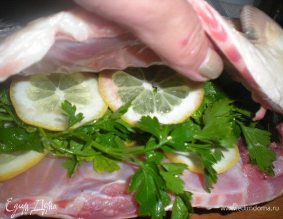 Один лимон нарезать тонкими кольцами,из другого выжать сок.Карпа посыпать белым перцем.В брюшко вложить веточки зелени и 2-3 кружка лимона.