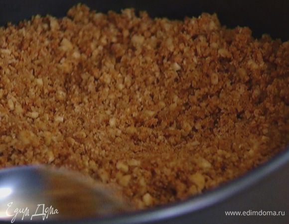 Перемешать растопленное масло и измельченное печенье, равномерно выложить в разъемную форму, слегка утрамбовать и отправить в холодильник.