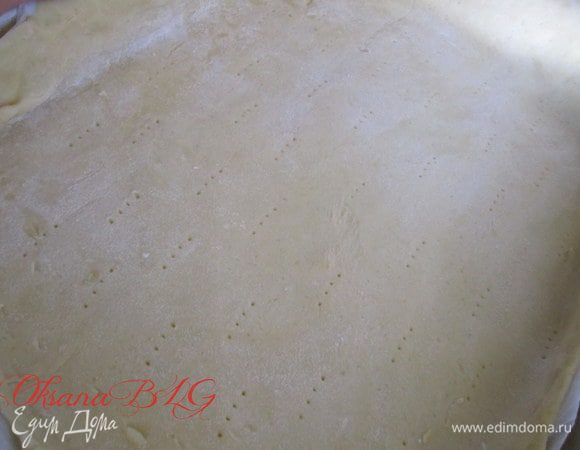 Большую часть теста тоненько раскатать, выложить на противень застеленный пергаментной бумагой. Наколоть вилкой.