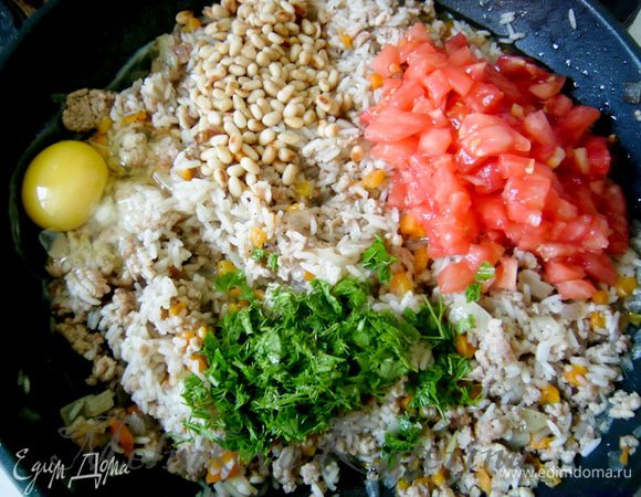 Помидоры обдать кипятком. Снять кожуру. Нарезать на кубики. Порубить мелко зелень. Мясную смесь снять с огня, дать немного остыть. Добавить к ней томаты, зелень, орешки, яйцо и тщательно все перемешать. 