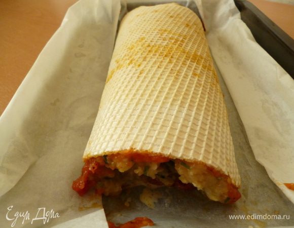 Теперь смотрим,что бы вафельный корж обмяк и его можно было свернуть рулетом.Рулет вместе с пергаментом выкладываем в форму для запекания.