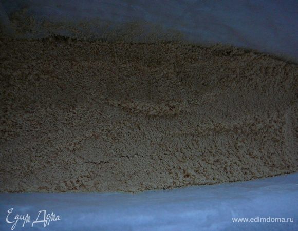 Печенье измельчить в крошку(перемолоть в блендере или перекрутить на мясорубке).Форму застелить пергаментом,пергамент предварительно смазать сливочным маслом.Высыпать в форму половину печенья.