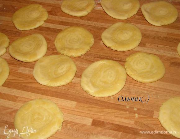 Каждый кусочек  кладём на срез и приплюскиваем ладонью, затем раскатываем скалкой в кружок.