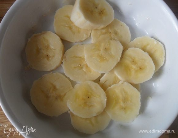 Форму смазать сливочным маслом,выложить нарезанный банан.