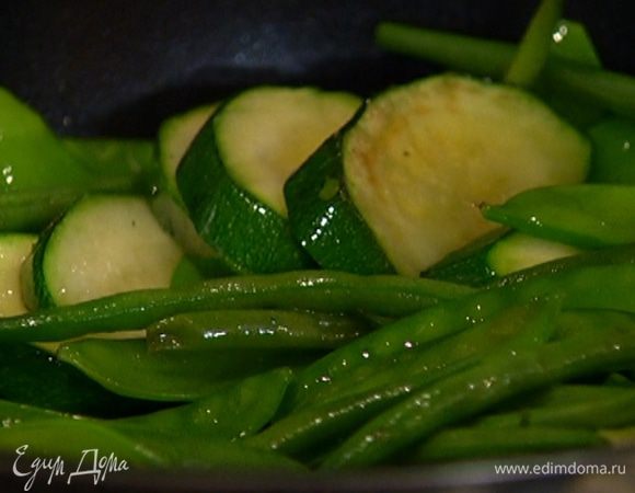 Добавить к цукини фасоль и горох, перемешать и слегка обжарить.