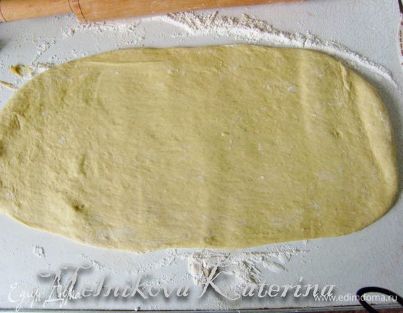 Тесто достать, обмять. Разделить на две равные части. Взять одну часть и раскатать скалкой в прямоугольник/овал.