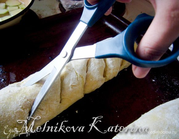 Когда тесто немного "подошло", нужно вооружиться ножницами. Сделать на каждом рулете надрезы под углом примерно 45 градусов на расстоянии 2-3 см. Надрезы делать почти до низу. 