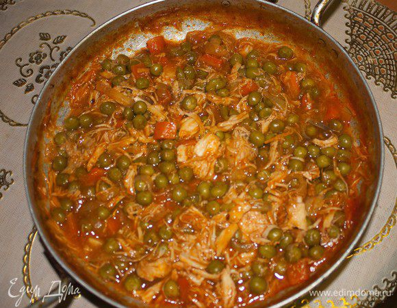 Курицу разделать на небольшие кусочки, натереть чесноком, растертым с солью, перцем, слегка (!) обжарить в высокой сковороде на оливковом масле.
Далее добавить небольшое количество воды и тушить на слабом огне. За пятнадцать минут до готовности положить мелко порезанные томаты, обжаренную крупными кубиками морковь, зеленый горошек, специи, листья петрушки и немного лаврового листа.

