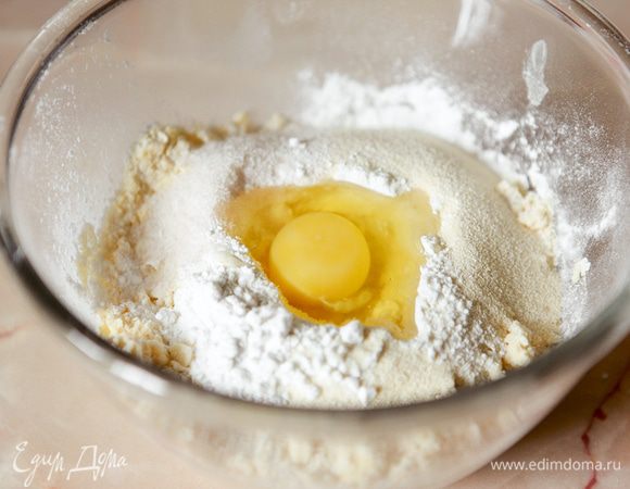К полученной крошке добавить сахарную пудру, ванильный сахар, манную крупу, разрыхлитель, яйцо.