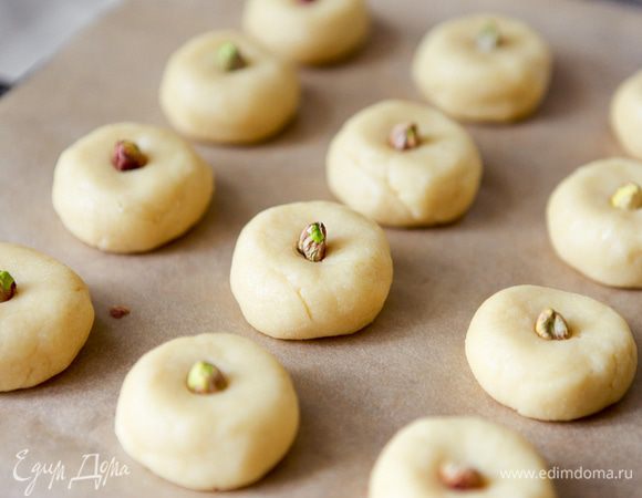 Из теста сформировать небольшие шарики, выложить их на противень, чуть прижать, а в середину вдавить фисташку. Выпекать в предварительно разогретой до 180 С духовке 25-30 мин. до зарумянивания.