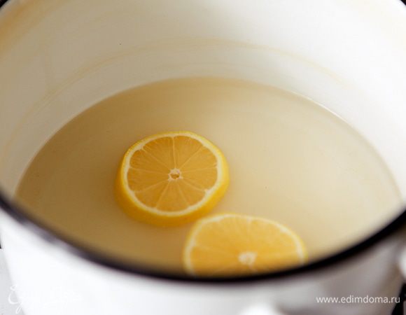 В кастрюлю налить воду, высыпать сахар и положить лимон. На сильном огне довести до кипения, затем на медленном огне дать покипеть 10 мин.