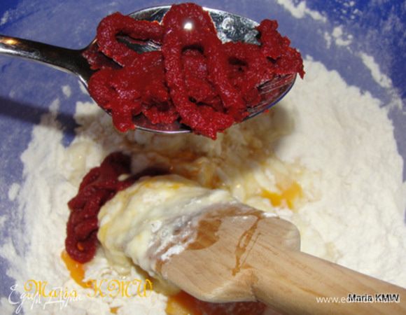 Добавляем к муке яйца по-одному, томатный сок и пасту, тщательно вымешиваем миксером или лопаткой.
