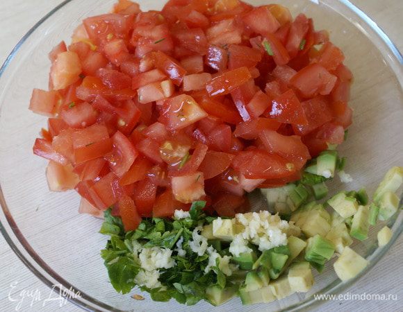 В миске перемешать мелко нарезанные томаты, выдавить чеснок (1 шт.) и мелко нарезать спелый авокадо, заправить одной столовой ложкой оливкового масла. 