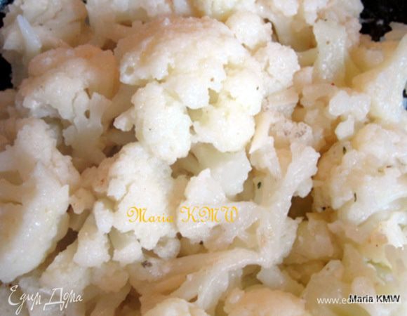 Цветную капусту почистить и разобрать на соцветия. Отварить в кипящей воде 5-7 минут. 
Выложить в блюдо, приправить сливочным маслом, болгарской солью или пряностями и солью по-вкусу. Посыпать еще горячую капусту твердым сыром, типа Пармезан или Гран Падано. Тщательно перемешать.